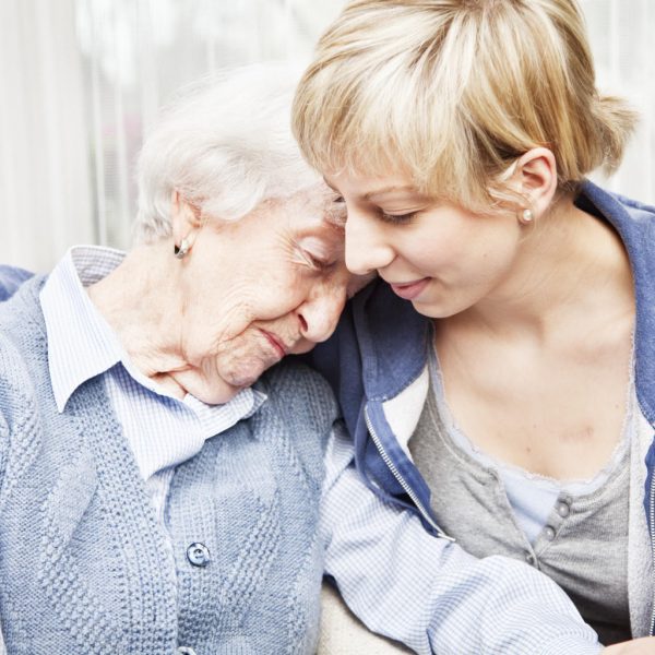 home caregiver consoling sad senior woman